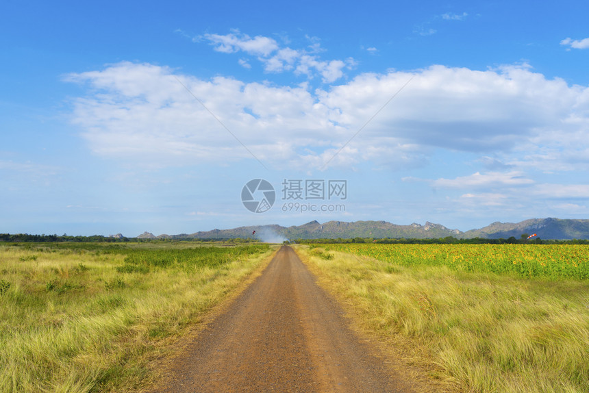 蓝色天空和云彩的农村道路图片