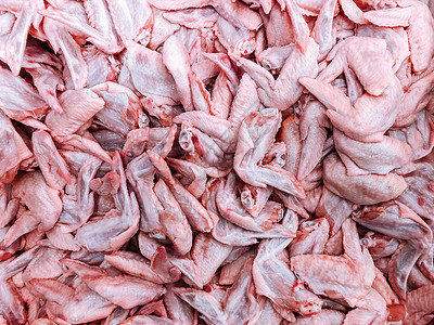 大堆生鲜鸡翅的顶端景镜头市场上的批发肉类产品图片