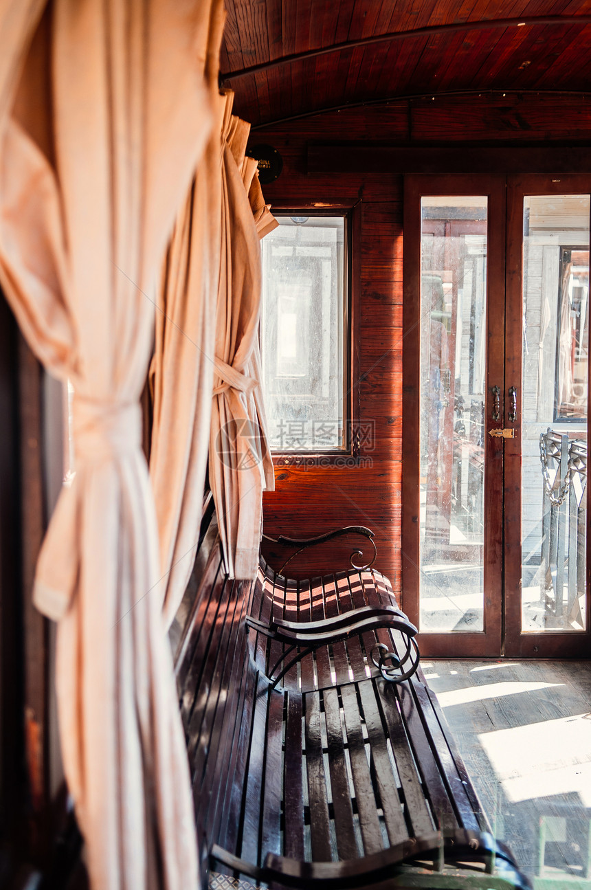 古老的经典木制列车内装有窗帘和下午的灯光漂亮木板椅硬和地图片