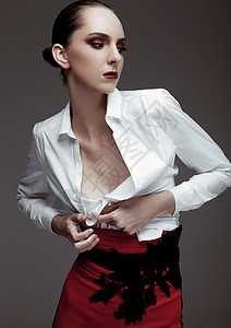 穿着红裤子和灰底白衬衫的漂亮时装模特背景图片