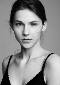 模型测试肖像以年轻的美丽时装模特在灰色背景上黑胸罩白照片图片
