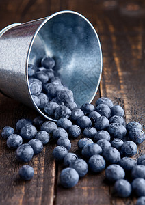 小型钢桶中的蓝莓木板上装有小钢桶天然健康食品图片