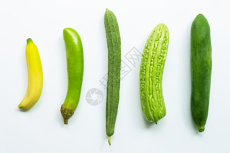 香蕉、绿色长茄子乳酪苦瓜白底绿木。图片