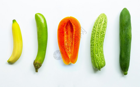 香蕉、绿长茄子熟木瓜苦白底绿木。图片