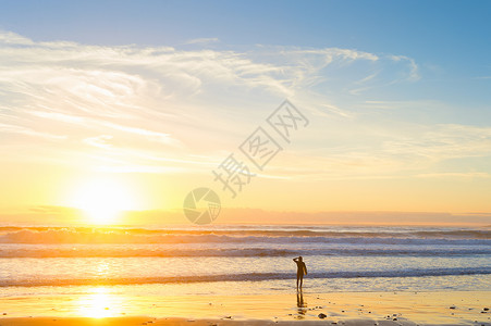 日落时在海边的冲浪者图片