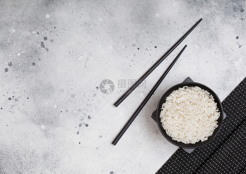 黑碗有煮的机巴斯马蒂茉米饭有黑筷子和甜豆酱放在石垫上浅的厨房桌底图片