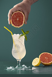 夏季用冰块薄荷叶和柑橘芳香果葡萄和柠檬在蓝底玻璃杯中冷饮图片