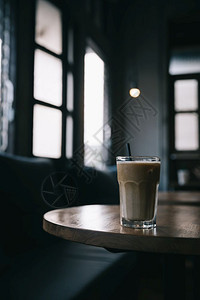 卡布奇诺或拿铁冰咖啡由店木制餐桌上的牛奶成图片