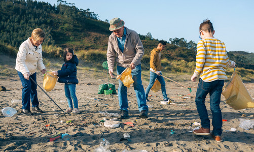 捡垃圾的孩子一群志愿者在海滩上捡垃圾背景