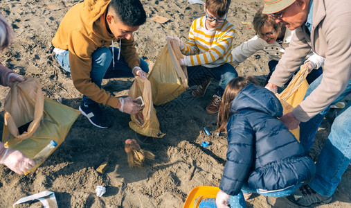 在海滩上捡垃圾的志愿者图片