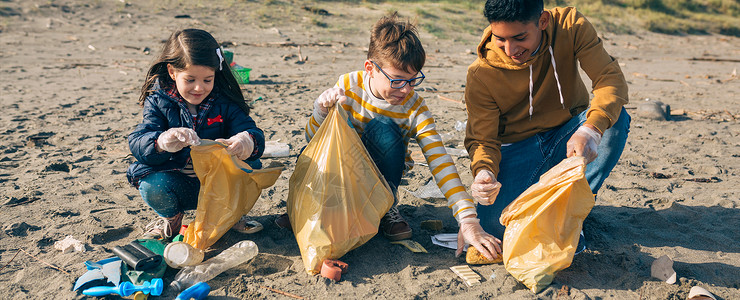 一群青年志愿者在海滩上捡垃圾图片