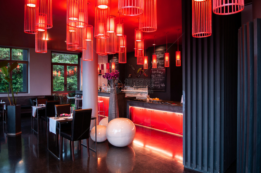 现代充满活力的室内酒吧休息里面有黑白音家具感的红花生灯色天板和黑闪亮的地板图片