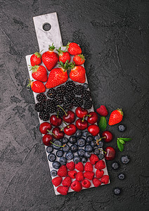 白色大理石板上的新鲜有机夏季果子酱深色厨房桌底背景草莓蓝黑和樱桃背景图片