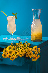 夏季框架冰冷的柠檬水杯冰和片蓝色的床头柜黄花朵图片
