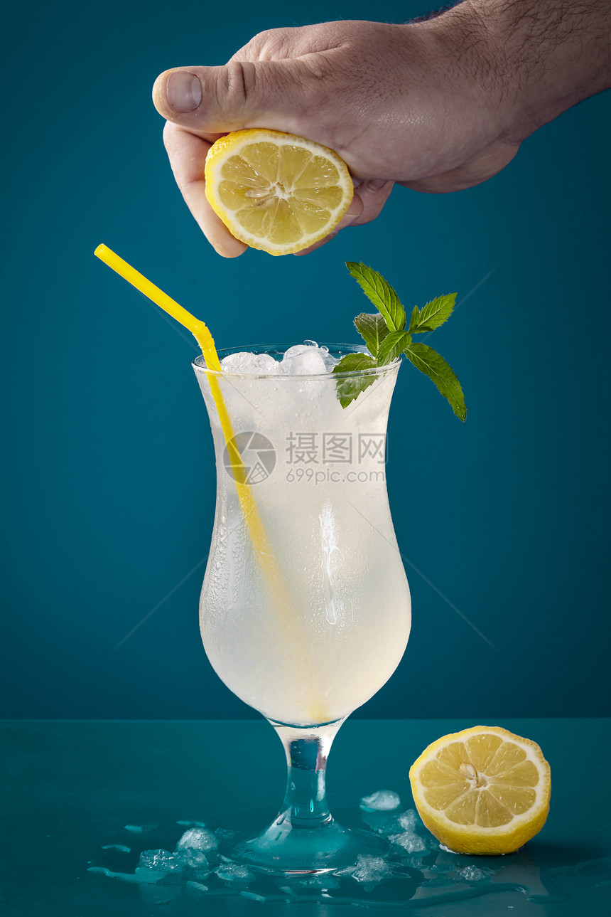 柠檬汁杯加冰和新鲜柠檬蓝色背景图片