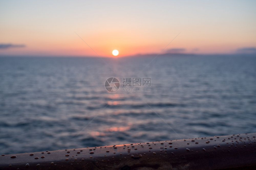 日出或黎明时游轮小在横渡海洋的小游轮茶轨上漂浮着水滴子在日出或黎明时游轮的茶轨上降下雨水图片