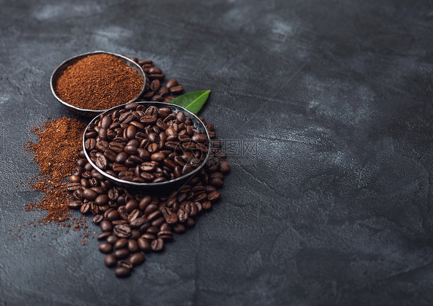 黑色上含地粉和咖啡树叶的新鲜有机咖啡豆文本空间图片