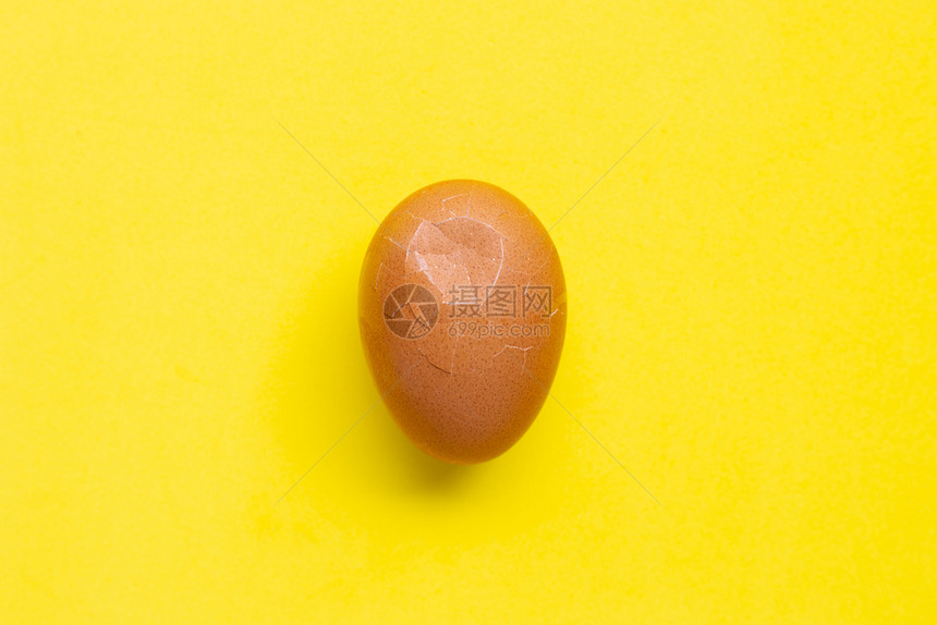 黄色背景上被解开的鸡蛋顶视图图片