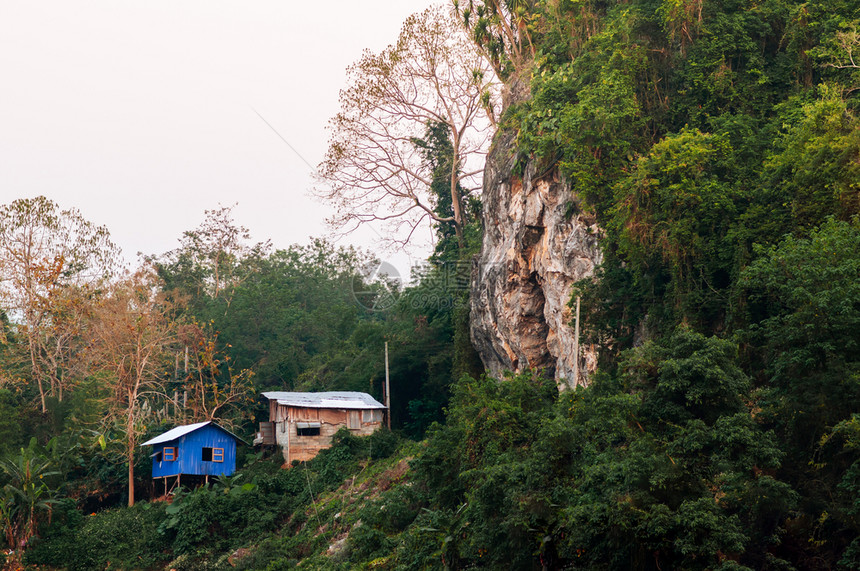 位于森林和亚山热带Luangprbnglos岩石悬崖的小型蓝色地方屋图片