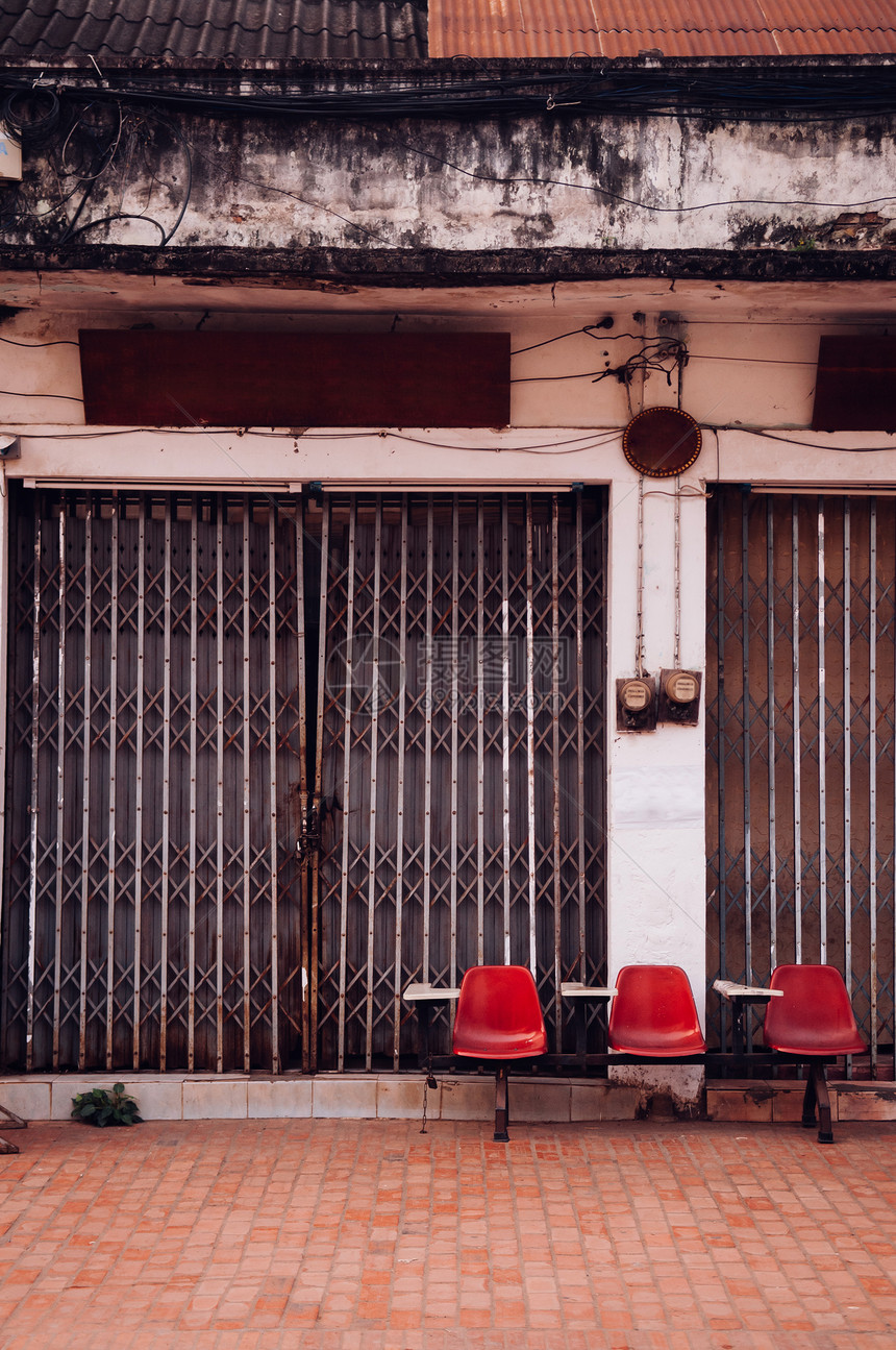 旧红色讲课台座椅和旧古建筑配有金属门和空人行道图片