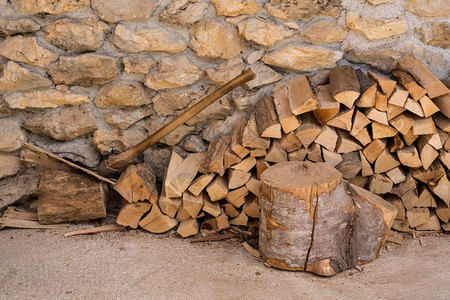砍碎的木柴和堆在一座生锈的农庄石墙上木柴堆在农庄的石墙上背景图片
