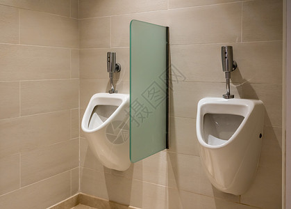 在男浴室内用自动冲水洗在男手间用两个自动冲水洗的手间用两个自动冲水小便池背景图片