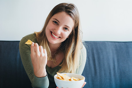 妇女在沙发上吃零食图片