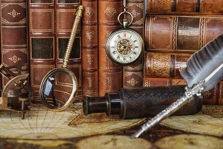 古老的手表导航仪器和银笔都印在古书的背景上图片