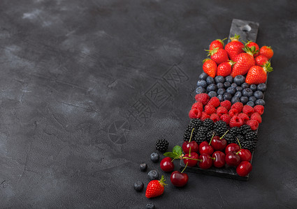 黑大理石板上色厨房桌底的大理石板上莓草蓝黑和樱桃图片