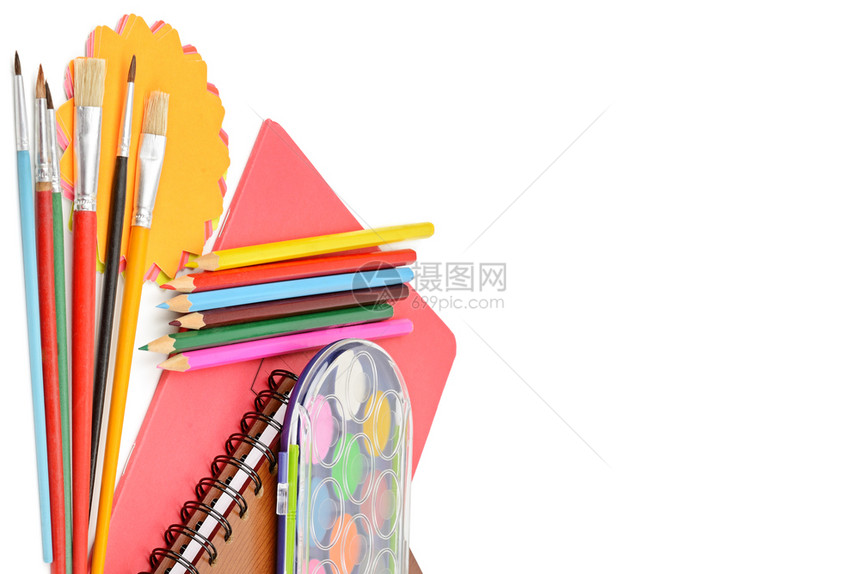白色背景上的彩铅笔油漆记本和其他文具图片