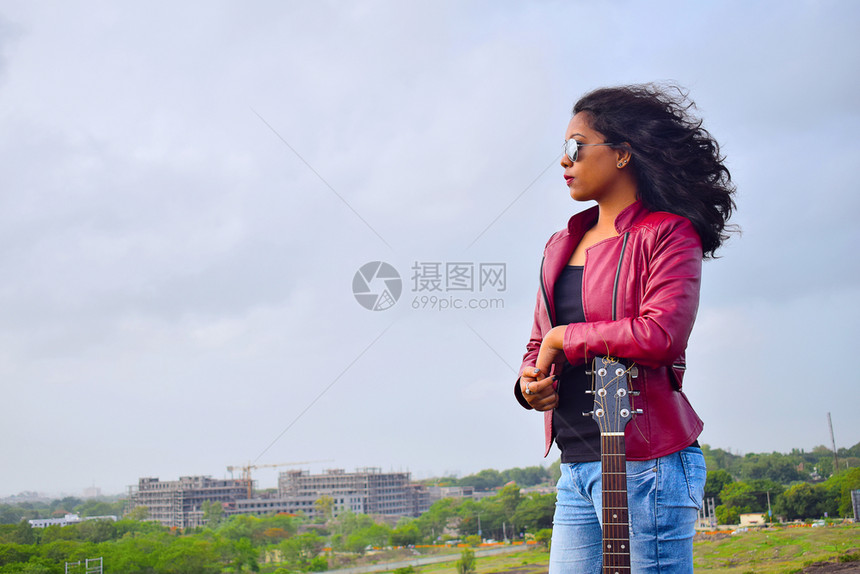 青年女孩站在草地上沉思图片