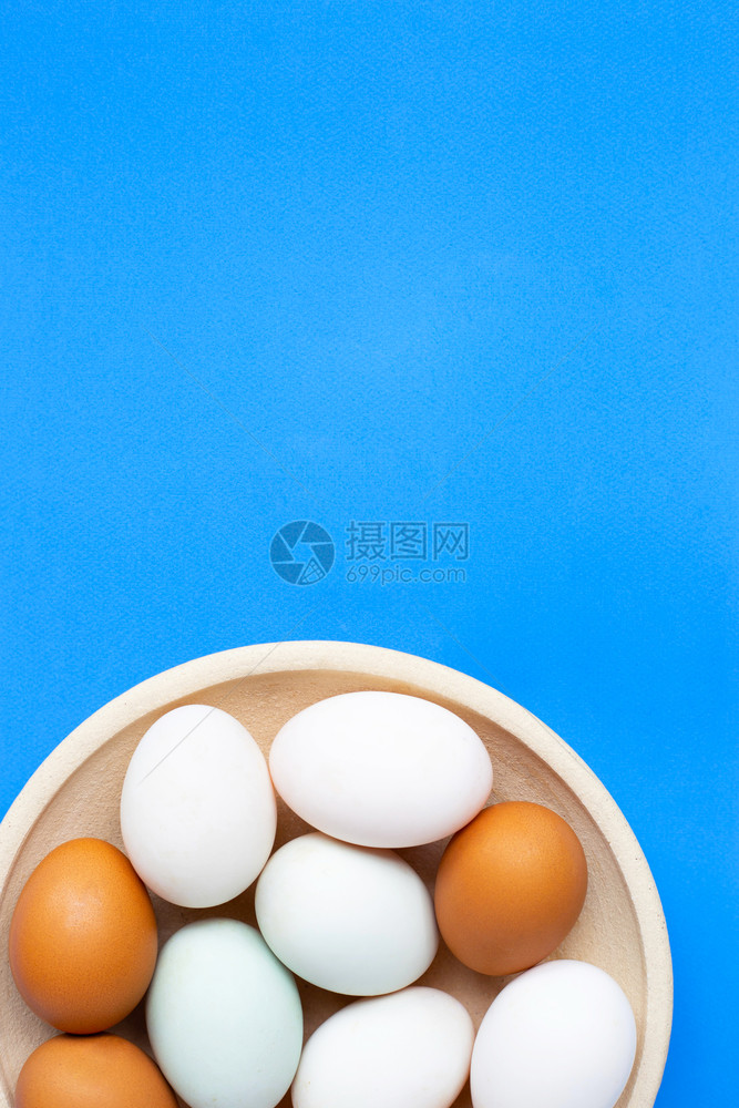 在蓝色背景的鸡蛋上带有复制空间的顶视图图片