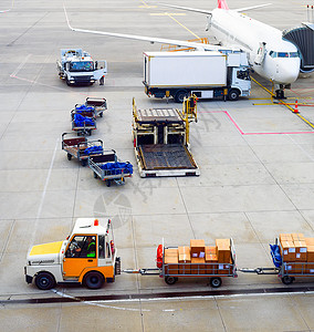 卡车运输机场跑道的行李车背景图片