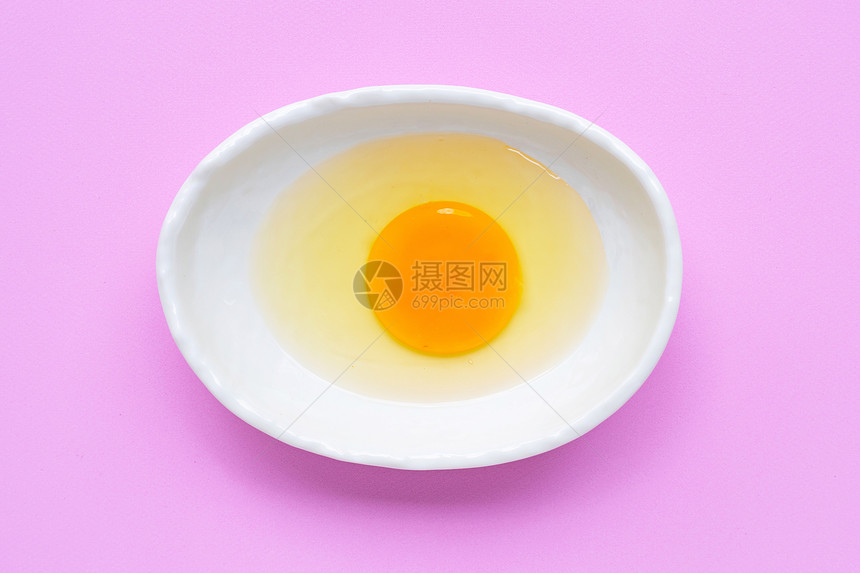粉红色背景的碗中蛋和白最高视图图片