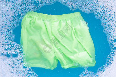绿色短裤浸泡在婴儿洗涤剂中图片
