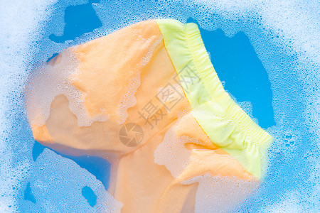 橙色短裤浸泡在婴儿洗涤剂中图片
