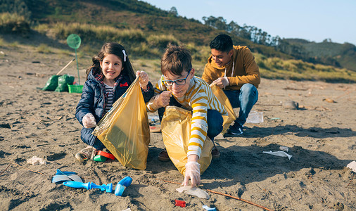 一群青年志愿者在海滩上捡垃圾图片