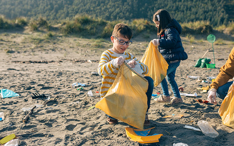 儿童志愿者在海滩上捡垃圾图片