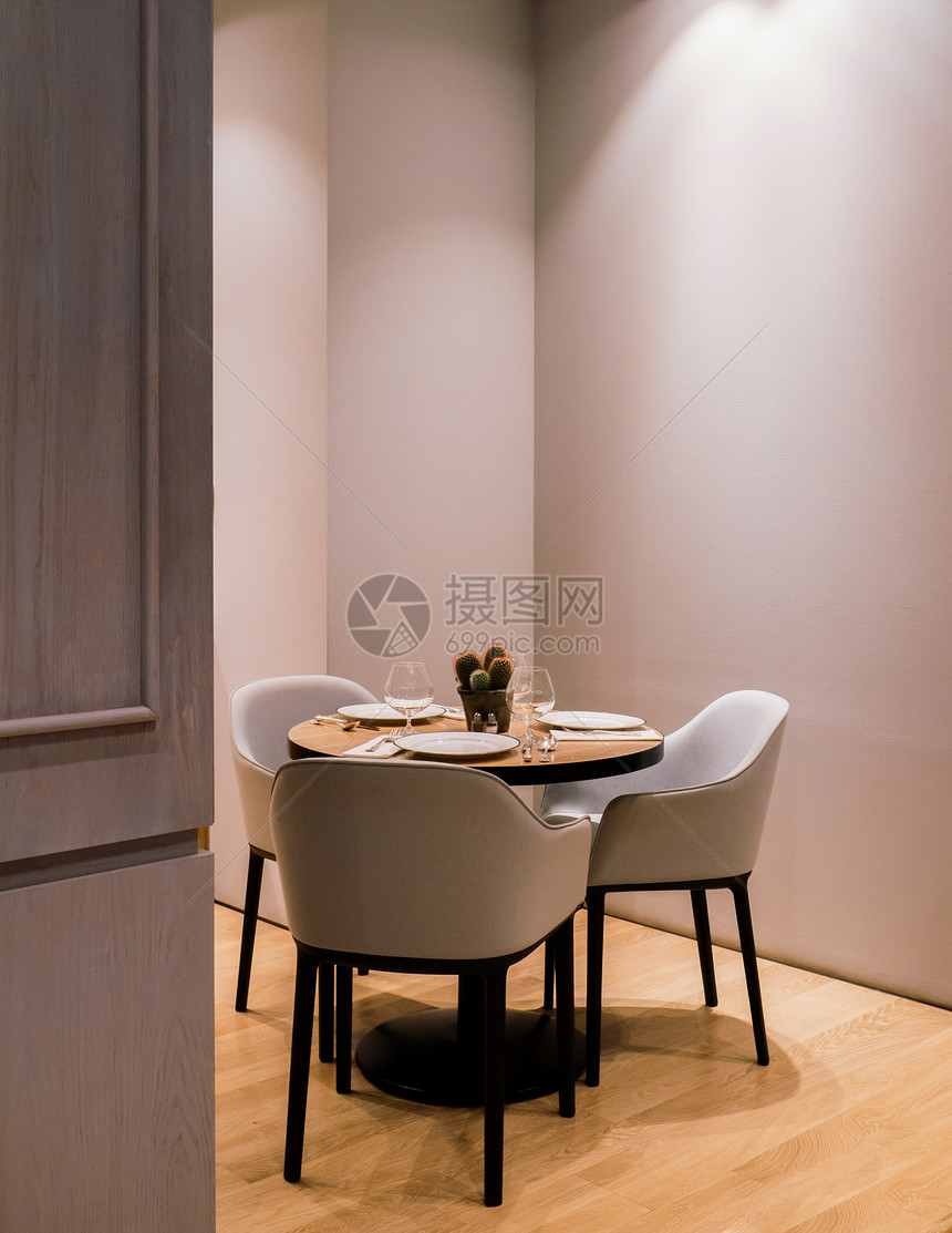 现代餐桌椅和布小仙人掌锅和温光下的葡萄酒杯图片