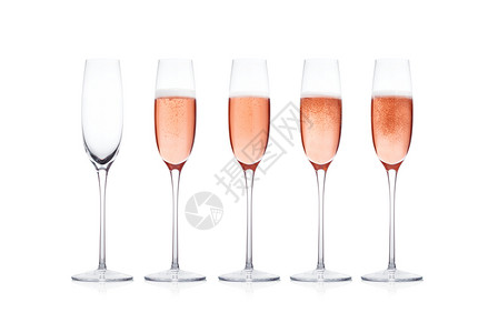 玫瑰粉红香槟杯白色背景上隔开的泡图片