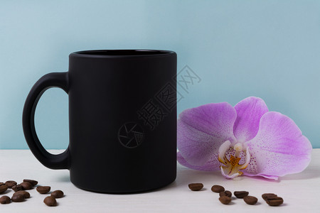 用紫兰花和咖啡豆的黑杯子空是用来促销品牌的图片