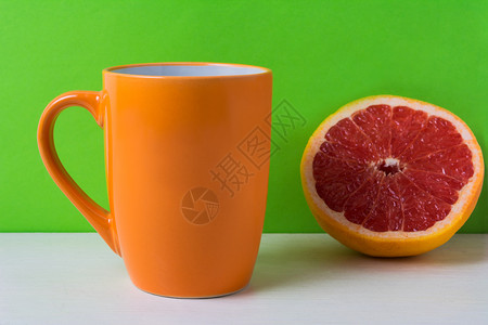 橙色咖啡卡布奇诺杯绿色背景的红葡萄油空杯用于设计促销图片