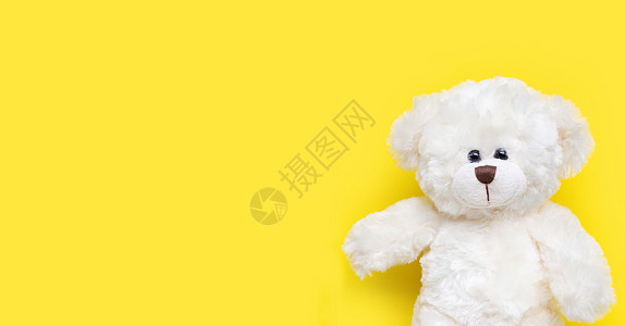黄色背景上的白熊玩具复制空格背景图片