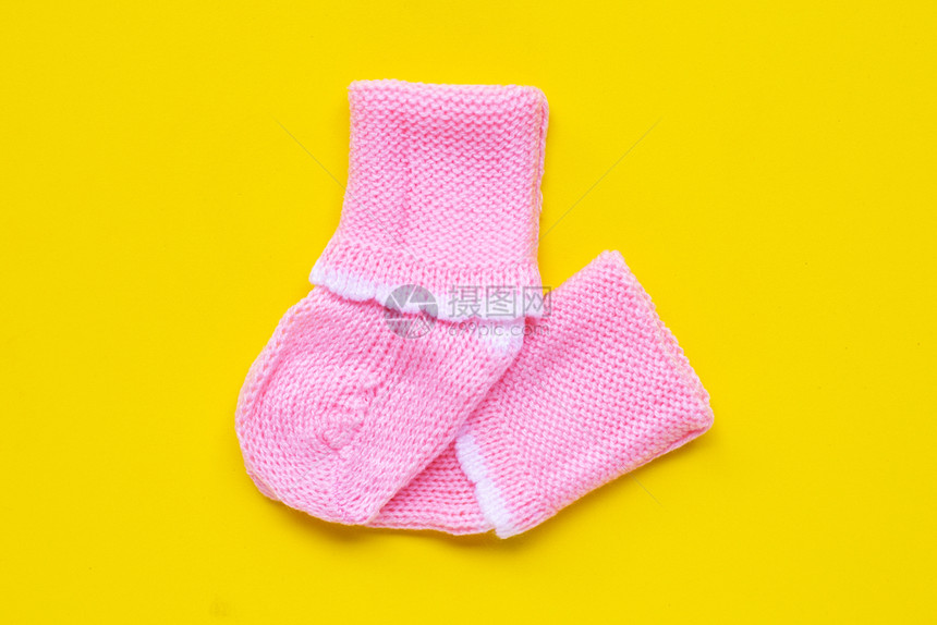 黄色背景的婴儿袜子顶部视图图片