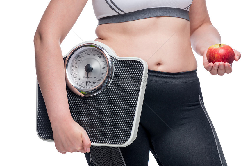 一个带着体重和一个苹果的胖女人选择了运动和健康饮食的概念照片图片