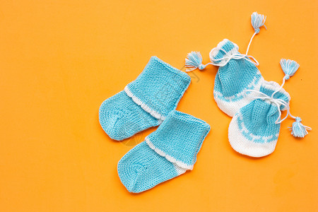 橙色背景的婴儿手套和袜子图片