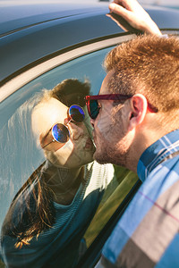 年轻夫妇在户外汽车的玻璃杯中亲吻年轻夫妇在玻璃杯中亲吻图片