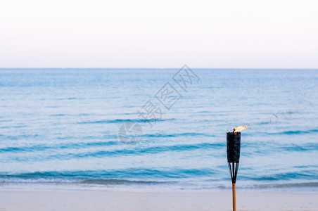 日落热带海滩的竹火炬和平夜晚的泰国夏海滩背景概念图片