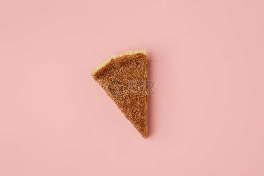 粉红色纸面背景上传统的南瓜派切片高于一个饼部分的视图最小后一个派切片图像感恩甜点图片