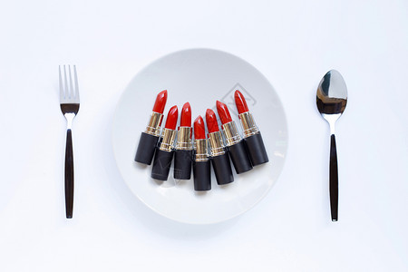 白餐上加口红背景上加叉子和勺美丽的化妆概念图片
